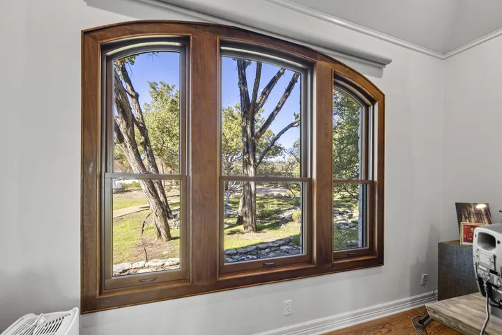 Wood-toned arched replacement window in a Georgetown, Texas home