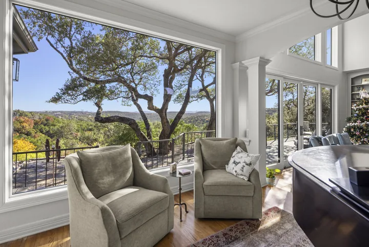 Large replacement picture window and adjoining doors opening to a tree-filled Georgetown, Texas view