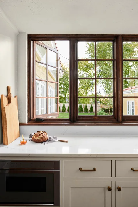 Dark wood divided-light replacement windows above a Georgetown, Texas kitchen counter